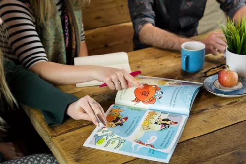 montre du doigt un dessin dans un livre illustré pour enfants