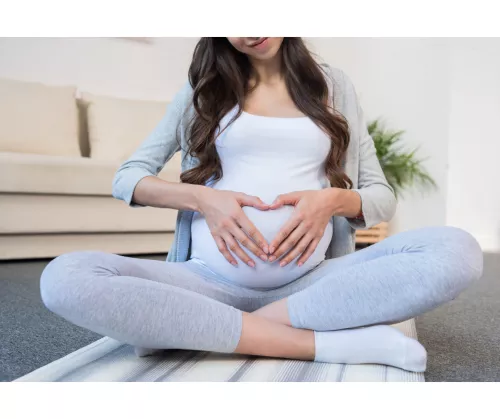 femme enceinte coeur avec les doigts